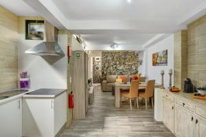 a kitchen and dining room with a stone wall at Host Albina in Funchal