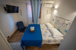 una piccola camera con letto blu e divano di Lighthouse Taranto a Taranto