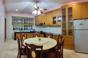 une cuisine avec une table et un réfrigérateur blanc dans l'établissement AT Unicorn Homestay Sibu - Large Parking, High-Speed WiFi, Wedding House, à Sibu