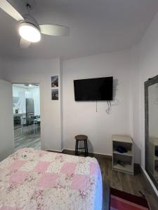 a bedroom with a bed and a flat screen tv at Galatea Puerto Sherry Apartamento in El Puerto de Santa María