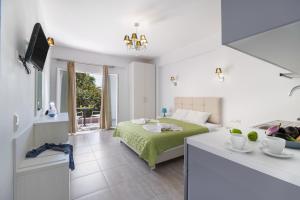 a white bedroom with a bed and a kitchen at Oasis Exclusive in Parga