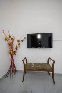 a bench with a vase of flowers and a tv at Casa bea in Taranto