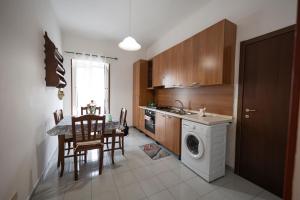 a kitchen with a washing machine and a table and chairs at Casa bea in Taranto +29 photos