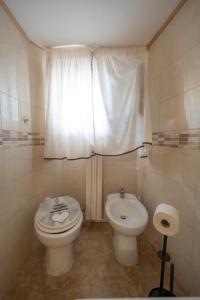 a bathroom with a toilet and a sink and a window at Casa bea in Taranto +3 photos