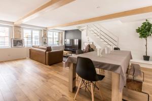 a living room with a table and a couch at Duplex d'Exception avec Patio Privé - Hyper Centre in Lille +12 photos