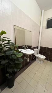 a bathroom with a sink and a toilet and a mirror at Kiki's room for men 8B in Melaka