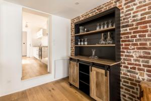 a brick wall in a kitchen with a counter and a mirror at Duplex d'Exception avec Patio Privé - Hyper Centre in Lille
