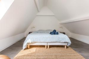 a white bedroom with a bed in a attic at Duplex d'Exception avec Patio Privé - Hyper Centre in Lille