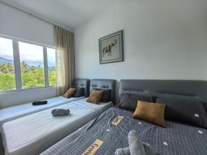 two beds sitting next to each other in a bedroom at Langkawi Simfoni Cassia Suite 04 9pax in Kuah +103 photos