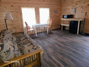 a living room with a couch and a table in a cabin at Letchworth Valley Campground Cabins in Bliss
