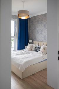 a bedroom with a large bed with a blue curtain at Apartament Glamour in Gdańsk +58 photos