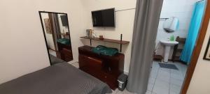 ein Schlafzimmer mit einem Bett und ein Badezimmer mit einem TV in der Unterkunft Recanto Green in São Leopoldo + 11 Fotos