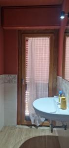 a bathroom with a white sink and a window at B&b LUME in Castelmauro