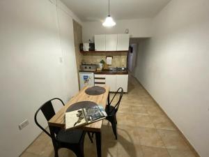 a kitchen with a wooden table and chairs in a room at Departamento Gallino in Corrientes