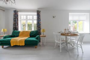 a living room with a green couch and a table at Stylish two bedroom apartment near Rookery Hall in Worleston