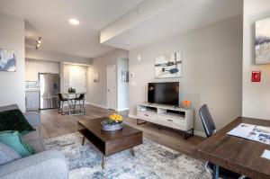 a living room with a couch and a tv at Luxury Apt On Harbor in Stamford