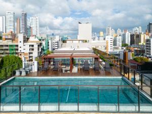 a swimming pool on the roof of a building with a city at Infinity at the Sea by Welkom in João Pessoa