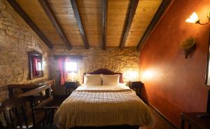 a bedroom with a bed in a stone room at Georgio's V Chalet Kalavrita in Kalavrita