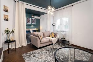 a living room with a couch and a bed at CenterSide Condo in Bucharest