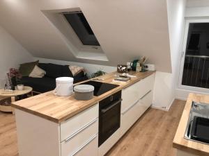 a kitchen with a stove top oven next to a couch at Monteurwohnung - Ferienwohnung in Piesberger