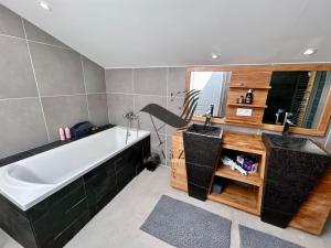 a bathroom with a large tub and a large mirror at Le Nid Marin - Spacieuse maison avec jardin in Moëze +25 photos