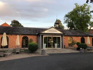 a brick building with umbrellas outside of it at Stylish two bedroom apartment near Rookery Hall in Worleston +17 photos