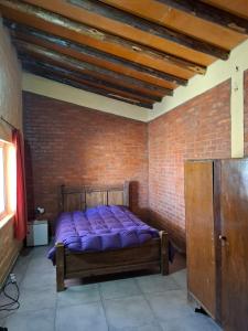 a bedroom with a bed in a brick wall at Sol y Sombra - Cabaña - Zonda - San Juan in Zonda