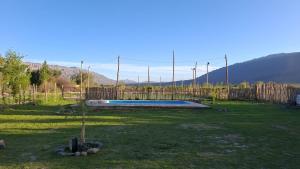 a yard with a swimming pool and a fence at Sol y Sombra - Cabaña - Zonda - San Juan in Zonda +16 photos