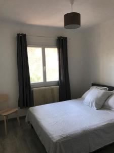 a bedroom with a bed and a window at Maison bord de Mer au calme sous les Pins in Carry-le-Rouet