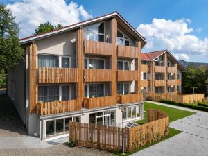 an apartment building with a wooden fence at BERGlässig Hotel - Halbpension Plus inkl Getränke in Bodenmais
