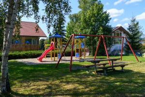 a playground with a bench and a swing at BERGlässig Hotel - Halbpension Plus inkl Getränke in Bodenmais