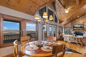 a dining room with a table and chairs and windows at Serenity in Blowing Rock