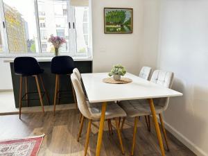a dining room with a white table and chairs at Siera Tirana Apartment in Tirana
