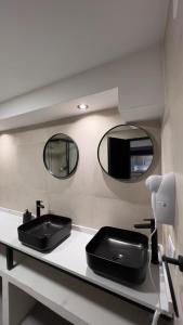 a bathroom with a black sink and two mirrors at Charcas Suites Palermo Soho in Buenos Aires