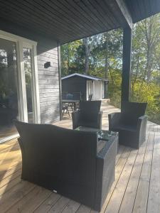 a porch with chairs and a table on a deck at 3 bedroom Cabin, 5 min walk to the ocean, 1 hours drive from Oslo in Fredrikstad +22 photos