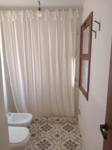 a bathroom with a toilet and a sink and a mirror at Las Piedras in Tafí del Valle +8 photos