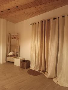 Zimmer mit weißen Vorhängen und Holzdecke in der Unterkunft Lar Dos Guerreiros, Omelro in Vila Nova de Milfontes