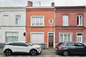 two cars parked in a parking lot in front of a brick building at Blue Evy in Croix