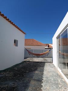 eine Hängematte im Innenhof eines weißen Hauses in der Unterkunft Lar Dos Guerreiros, Omelro in Vila Nova de Milfontes + 15 Fotos