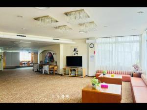 ein Wohnzimmer mit Sofa und Flachbildfernseher in der Unterkunft 三河温泉酒店 in Nishio