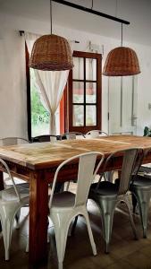 una mesa de comedor con sillas blancas alrededor en Anastasia Rústica y acogedora, en Córdoba 13 fotos más