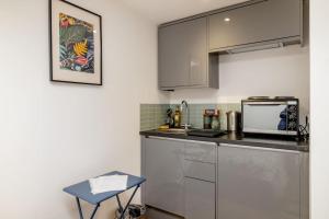 a kitchen with a sink and a microwave at Self contained two room studio apartment, own entrance, private parking in Brighton & Hove