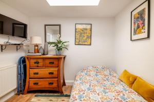 a bedroom with a bed and a dresser and a mirror at Self contained two room studio apartment, own entrance, private parking in Brighton & Hove