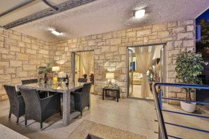 a room with a stone wall and a table and chairs at Villa Antonija in Ražanj