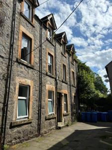an old brick building with windows on the side at Combie Lane Apartments in Oban