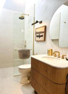 ein Badezimmer mit Toilette, Waschbecken und Spiegel in der Unterkunft Chic Bouldin Townhouse in Central Austin in Austin + 14 Fotos