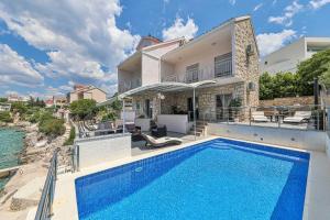 a swimming pool in front of a house at Villa Antonija in Ražanj