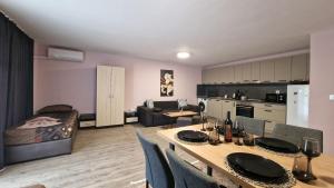 a living room with a dining room table and a kitchen at Морски Рай in Varna City