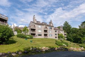 a large building on top of a grassy hill at Mount Snow Lodging in Dover
