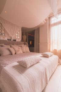 una camera bianca con un grande letto bianco con cuscini di Evāra a Herk-de-Stad